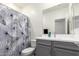 Well-lit bathroom with a gray vanity, modern fixtures, and a decorative shower curtain at 286 E Raleigh Dr, Chandler, AZ 85286