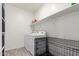 Bright laundry room with a washer and dryer, ample shelving, and a practical dog kennel at 286 E Raleigh Dr, Chandler, AZ 85286