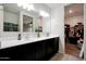 Bathroom featuring double sinks and a walk-in closet with a lot of shelves and storage at 30777 W Whitton Ave, Buckeye, AZ 85396