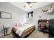 A cozy bedroom with a ceiling fan, a comfortable bed, and a dedicated workspace at 30777 W Whitton Ave, Buckeye, AZ 85396