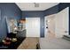 A bedroom featuring modern black dresser, blue accent wall and white closet at 30777 W Whitton Ave, Buckeye, AZ 85396