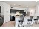 Bright kitchen area with granite countertops, stainless steel appliances, and dark cabinets at 30777 W Whitton Ave, Buckeye, AZ 85396