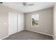 Bedroom features a ceiling fan, window, and a closet with sliding doors at 322 N 78Th Pl, Mesa, AZ 85207
