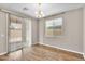 Bright dining room with sliding glass door and chandelier, featuring wood-look floors at 322 N 78Th Pl, Mesa, AZ 85207