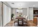 Bright dining room with wood floors, modern chandelier, and a large sliding glass door at 322 N 78Th Pl, Mesa, AZ 85207