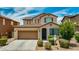 Charming two-story home featuring a well-manicured lawn, a two-car garage, and decorative shutters at 322 N 78Th Pl, Mesa, AZ 85207