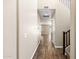 Inviting hallway with wood flooring leading to various rooms and staircase with dark trim at 322 N 78Th Pl, Mesa, AZ 85207