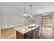 Open concept kitchen features an island with sink, dark wood floors, and dining and living areas at 322 N 78Th Pl, Mesa, AZ 85207