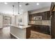 Modern kitchen featuring granite countertops, dark cabinetry, stainless steel appliances, and pendant lighting at 322 N 78Th Pl, Mesa, AZ 85207