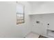 Bright laundry room featuring a window, white walls, built in shelving and tile flooring at 322 N 78Th Pl, Mesa, AZ 85207