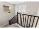Stairway with dark wood banister features bright light from two window views at 322 N 78Th Pl, Mesa, AZ 85207