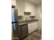 Galley kitchen features updated stainless steel appliances, granite countertops, and crisp white cabinetry at 3229 W Cholla St, Phoenix, AZ 85029