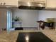 Kitchen view featuring a granite countertop, stainless range hood, and an opening to the living room at 3229 W Cholla St, Phoenix, AZ 85029