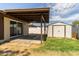 View of backyard featuring covered patio, storage shed, block fence, and grassy area at 3719 W Griswold Rd, Phoenix, AZ 85051