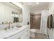 Beautifully remodeled bathroom with tiled shower, modern fixtures, white cabinets and marble countertops at 3719 W Griswold Rd, Phoenix, AZ 85051