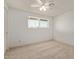 Well-lit bedroom featuring neutral carpet and a window offering outdoor views and a ceiling fan at 3719 W Griswold Rd, Phoenix, AZ 85051