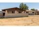 A neutral colored single-story home featuring a spacious front yard and a covered porch at 3719 W Griswold Rd, Phoenix, AZ 85051