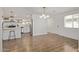 Open kitchen with stainless steel appliances, white cabinets, and dining area with stylish pendant lighting at 3719 W Griswold Rd, Phoenix, AZ 85051