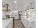 Modern kitchen featuring stainless steel appliances, white cabinets, floating shelves and wood-look tile at 3719 W Griswold Rd, Phoenix, AZ 85051
