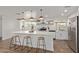 Bright kitchen with white cabinets, stainless steel appliances, a kitchen island, and wood-look tile flooring at 3719 W Griswold Rd, Phoenix, AZ 85051