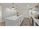 Spacious kitchen with a large island, white cabinets, stainless steel appliances, and wood-look tile flooring at 3719 W Griswold Rd, Phoenix, AZ 85051