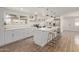 Modern kitchen with white cabinets, stainless steel appliances, an island with bar seating, and wood-look tile at 3719 W Griswold Rd, Phoenix, AZ 85051