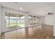 Spacious living room featuring wooden tile floors, large windows, and access to the backyard at 3719 W Griswold Rd, Phoenix, AZ 85051
