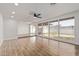 Bright living room with wood-look tile flooring and large windows overlooking the backyard at 3719 W Griswold Rd, Phoenix, AZ 85051