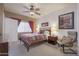 Bedroom with a queen bed, ceiling fan, chair and neutral colored walls at 3830 E Lakewood Pkwy # 1057, Phoenix, AZ 85048