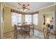 Bright dining area with a ceiling fan, large windows, and a view into the adjacent bedroom and kitchen at 3830 E Lakewood Pkwy # 1057, Phoenix, AZ 85048