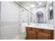 Bright bathroom featuring a glass-enclosed shower and a vanity with wood cabinets at 3935 E Rough Rider Rd # 1039, Phoenix, AZ 85050