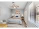 Bright bedroom with a ceiling fan, white trim, a large window, a bed, and stylish decor at 3935 E Rough Rider Rd # 1039, Phoenix, AZ 85050