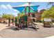 Community playground with slides, climbing structures, a small clubhouse, and shaded areas at 3935 E Rough Rider Rd # 1039, Phoenix, AZ 85050