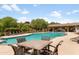 Outdoor swimming pool with lounge chairs, umbrellas, a shade structure, and lush landscaping at 3935 E Rough Rider Rd # 1039, Phoenix, AZ 85050