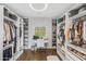 Spacious walk-in closet featuring a desk, built-in shelves, drawers, hanging racks, and a large window at 3935 E Rough Rider Rd # 1039, Phoenix, AZ 85050