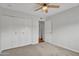 Bright bedroom featuring carpeted floors, a ceiling fan, and double closets at 4102 W Golden Ln, Phoenix, AZ 85051