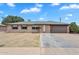 Charming single-story home featuring a two-car garage and a large front yard with mature landscaping at 4102 W Golden Ln, Phoenix, AZ 85051