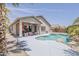 Gorgeous backyard featuring a sparkling pool, covered patio, and a lush tropical palm tree at 43319 W Oakland Ct, Maricopa, AZ 85138