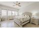 Cozy bedroom with tufted headboard, decorative pillows, and a ceiling fan at 43319 W Oakland Ct, Maricopa, AZ 85138