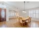 Open-concept dining room with wood floors, decorative lighting, and large windows with plantation shutters at 4353 W Walton Way, Chandler, AZ 85226