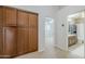 Hallway leading to bedroom and bathroom with wood cabinet storage in the hallway and tan carpeting at 4353 W Walton Way, Chandler, AZ 85226