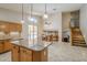 Open kitchen with a large island, stainless appliances, adjacent to a dining area, and staircase at 4353 W Walton Way, Chandler, AZ 85226
