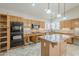 Well-lit kitchen with stainless appliances, granite countertops, a center island and wooden cabinets at 4353 W Walton Way, Chandler, AZ 85226