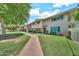 Inviting townhome showcasing a well-manicured lawn, mature trees, and a charming walkway to the front door at 4599 N 17Th Ave, Phoenix, AZ 85015