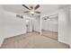 Primary bedroom featuring soft carpet, fan, walk-in closet and ensuite bathroom at 4599 N 17Th Ave, Phoenix, AZ 85015