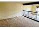 Spacious room with neutral carpet and black railing, offering a versatile living space at 4727 E Euclid Ave, Phoenix, AZ 85044