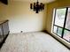 Bright living room with large windows, neutral carpet, and chandelier, providing ample natural light at 4727 E Euclid Ave, Phoenix, AZ 85044