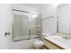 Bathroom featuring a shower over tub with sliding glass door, toilet, and sink with cabinets and drawers at 5035 N 17Th Ave # 205, Phoenix, AZ 85015