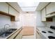 Bright kitchen with white cabinets, skylight, and stainless steel sink and adjacent dining area with hardwood floors at 5035 N 17Th Ave # 205, Phoenix, AZ 85015