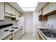 Modern kitchen featuring white appliances, white cabinetry, and a laundry area at 5035 N 17Th Ave # 205, Phoenix, AZ 85015